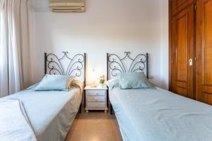 two beds sitting next to each other in a bedroom at MalagaSuite Dreamy Village in Arroyo de la Miel