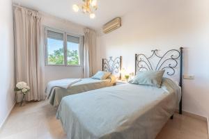 a bedroom with two beds and a window at MalagaSuite Dreamy Village in Arroyo de la Miel