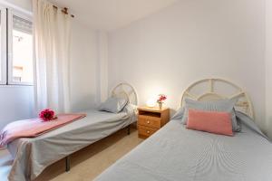 a bedroom with two beds and a dresser and a window at MalagaSuite Dreamy Village in Arroyo de la Miel +14 photos