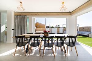 Un comedor con una mesa y sillas negras. en Villa Sofía Maspalomas, en San Bartolomé