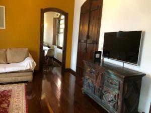 sala de estar con TV de pantalla plana y sofá en Casa Temporada com Tranquilidade e Aconchego - Petrópolis - RJ en Petrópolis