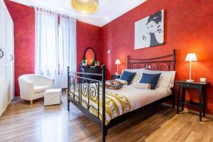 a bedroom with a bed and a red wall at Tirso 9 in Milan