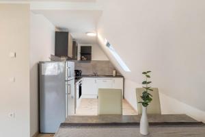 Unique Apartments Wiesloch في فيسلوخ: مطبخ مع ثلاجة بيضاء ودرج