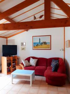 a living room with a red couch and a tv at Zeepolder Ii 70 in De Haan