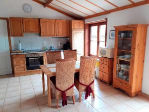 a kitchen with a wooden table and chairs in it at Zeepolder Ii 70 in De Haan