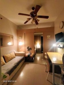 - un salon avec un canapé et un ventilateur de plafond dans l'établissement Condo by Bambie near NAIA airport, à Manille