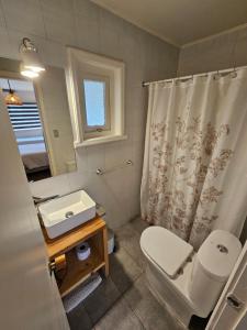 uma casa de banho com um WC branco e um lavatório. em Casa Ellies Hotel Boutique em Puerto Varas