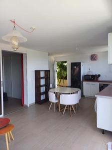a kitchen and living room with a table and chairs at Kazpucins T2 vue mer et pitons in Les Trois-Îlets