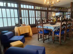 - une salle à manger avec une table, des chaises et des fenêtres dans l'établissement Bela casa de 4 suítes em Geribá, à Búzios