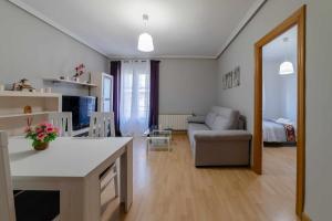 uma cozinha e sala de estar com um sofá e uma mesa em Lormar Apartamento em Zamora