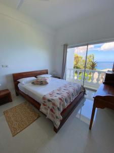 a bedroom with a bed with a view of the ocean at Reve Blêu in Glacis