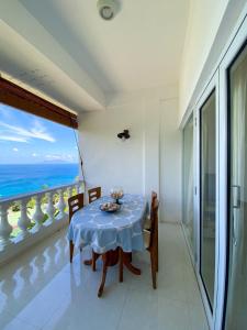 a dining room with a table and a view of the ocean at Reve Blêu in Glacis