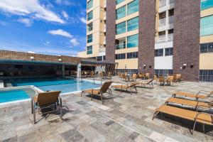 a patio with a pool and chairs and a building at PIAZZA DIROMA - ACQUA PARK, SPLASH e SLIDE in Caldas Novas