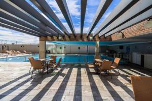 a patio with a table and chairs and a pool at PIAZZA DIROMA - ACQUA PARK, SPLASH e SLIDE in Caldas Novas