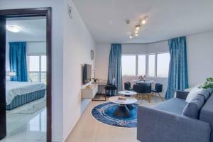 Premium 1BHK near Metro station Dubai Marina & JBR في دبي: غرفة معيشة مع أريكة وسرير وطاولة