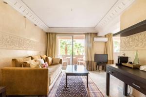 ein Wohnzimmer mit einem Sofa und einem Tisch in der Unterkunft Somptueux Duplex au coeur de l'Hivernage in Marrakesch