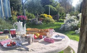 una mesa de picnic con comida en un jardín en Le chant des oiseaux, en Montmartin-sur-Mer