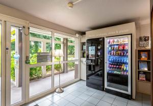 un magasin avec un réfrigérateur rempli de nombreuses boissons dans l'établissement B&B HOTEL Brest Kergaradec Aéroport Gouesnou, à Brest