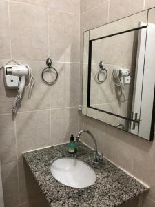 W łazience znajduje się umywalka i lustro. w obiekcie Apartamento Frente para o mar w mieście Ilha Comprida