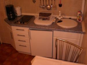 a small kitchen with a counter and a sink at Gästehaus Wolf in Sierksdorf