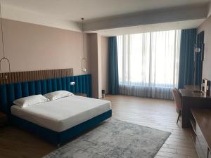1 dormitorio con cama, escritorio y cama sidx sidx sidx sidx en Bolv Hotel, en Durrës