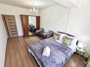 ein Schlafzimmer mit einem Bett mit zwei Handtüchern darauf in der Unterkunft Appartments " Zhetysu-4" in Almaty