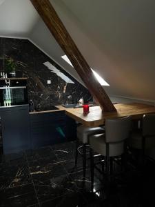 a kitchen with a wooden table and some chairs at NEW GUEST HOUSE 13 in Maribor