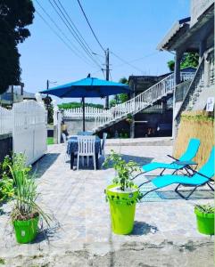 patio ze stołem, krzesłami i parasolem w obiekcie La villa du soleil 971 w mieście Anse-Bertrand