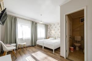 a bedroom with a bed and a table and chairs at Pensiunea Bella in Arad