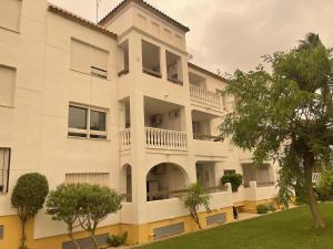 維拉馬丁的住宿－Villamartín PlazaGolf，公寓大楼设有阳台和树木