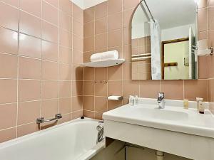 La salle de bains est pourvue d'un lavabo, d'une baignoire et d'un miroir. dans l'établissement Appartement Val-d'Isère, 3 pièces, 6 personnes - FR-1-411-897, à Val dʼIsère