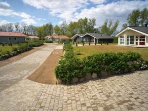 a brick walkway in front of a house at Dänische Ferienhäuser am Salzhaff Haus Strandhafer in Gollwitz