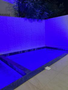 een zwembad verlicht met paarse lichten bij Go to the top in Dakar