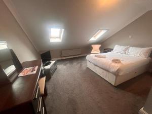 1 dormitorio con 1 cama grande y 2 ventanas en The Dunes Hotel en Barrow in Furness