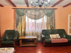 a living room with two chairs and a table and a window at Mala Praha in Uzhhorod