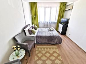 ein Schlafzimmer mit einem Bett, einem Sofa und einem Fenster in der Unterkunft Appartments " Zhetysu-4" in Almaty