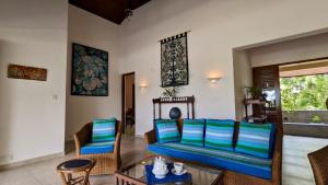 a living room with a blue couch and chairs at Khomba Lodge in Tangalle
