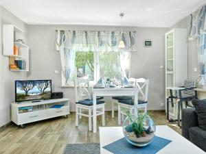 a living room with a table and chairs and a television at Haus Otto in Insel Poel