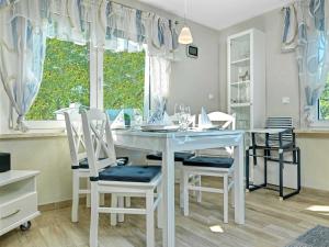 a white dining room with a white table and chairs at Haus Otto in Insel Poel