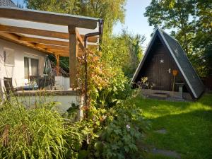 un jardin avec une petite cabine en arrière-plan dans l'établissement Haus Otto, à Poel