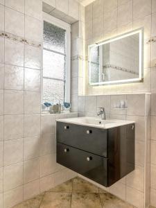 ein Bad mit einem Waschbecken und einem Spiegel in der Unterkunft Hus an Diek in Insel Poel