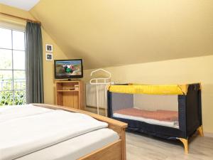 ein Schlafzimmer mit einem Etagenbett und einem TV in der Unterkunft Hus an Diek in Insel Poel