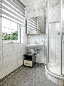 ein weißes Bad mit einem Waschbecken und einer Dusche in der Unterkunft Hus an Diek in Insel Poel