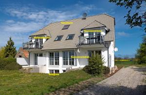 une maison blanche avec des mots jaunes sur elle dans l'établissement Haus Sonnenschein Sommerwiese, à Poel