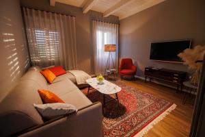 Vila ROBIDA & SPA في Črni Kal: غرفة معيشة مع أريكة وطاولة