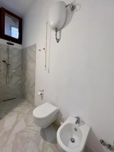een witte badkamer met een toilet en een wastafel bij Il sogno di Lucia in Amelia