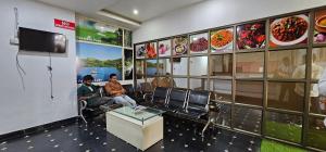 a restaurant with two men sitting in a waiting room at KTM PRINCEINN in Kalpetta