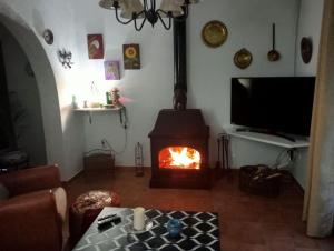 sala de estar con chimenea y TV en FINCA EL ROMERO, Finca a 15 minutos de Sevilla, en Alcalá del Río