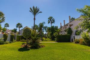 un cortile con palme e una casa di AB Properties - Chic House Marbella - 3 mm to Puerto Banús and Beach - Golden Mile - Direct access to Pool and Tropical Garden a Marbella