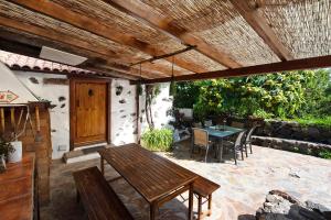 eine Terrasse mit einem Holztisch und Stühlen sowie einem Tisch und einem Tisch in der Unterkunft Hesperia in Icod de los Vinos